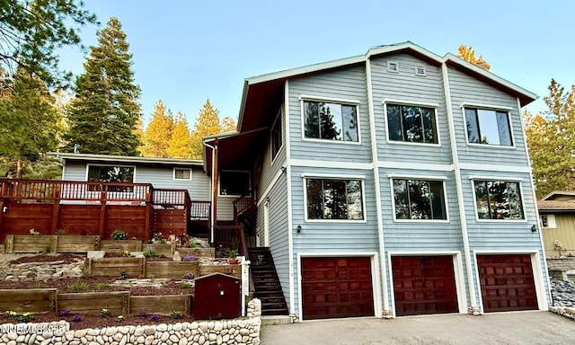 315 Paiute Dr, Zephyr Cove, NV 89448 - view of front of property featuring stairs, a garage, asphalt driveway, a deck, and a vegetable garden