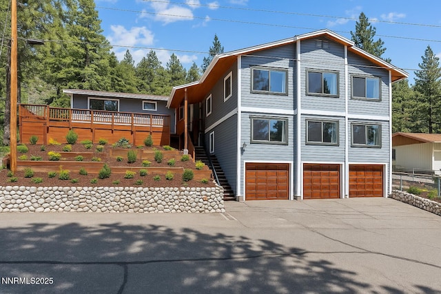 315 Paiute Dr, Zephyr Cove, NV 89448 - view of front of home with concrete driveway, an attached garage, stairway, a deck, and a garden