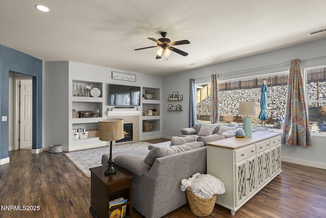 11760 Valley Crest Dr, Sparks, NV 89441 - living room featuring a ceiling fan, a tile fireplace, dark wood-type flooring, baseboards, and a textured ceiling