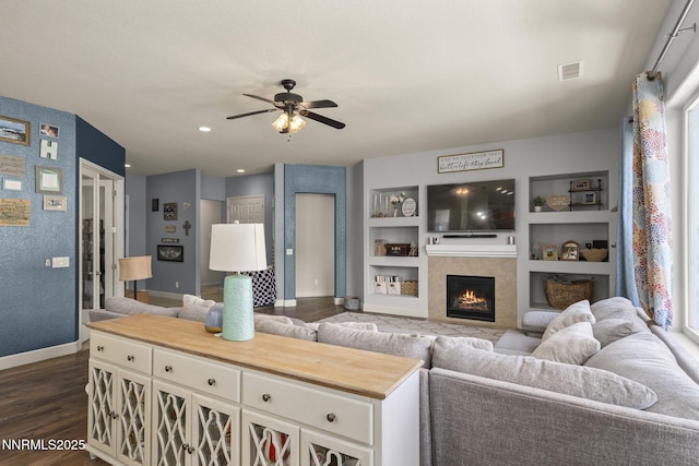 11760 Valley Crest Dr, Sparks, NV 89441 - living area with baseboards, ceiling fan, dark wood-type flooring, built in shelves, and a lit fireplace