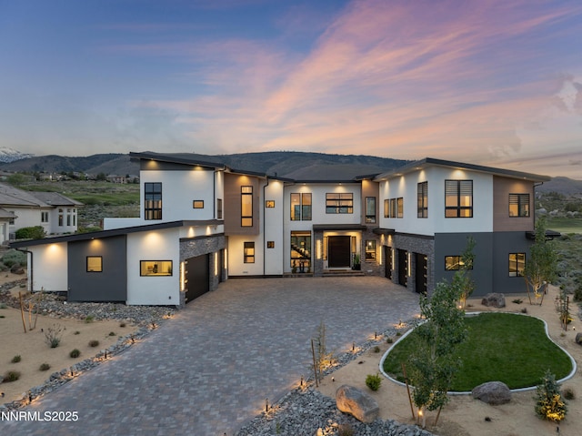 3041 Palmer Pointe Ct, Reno, NV 89511 - contemporary home with stucco siding, an attached garage, decorative driveway, and a mountain view