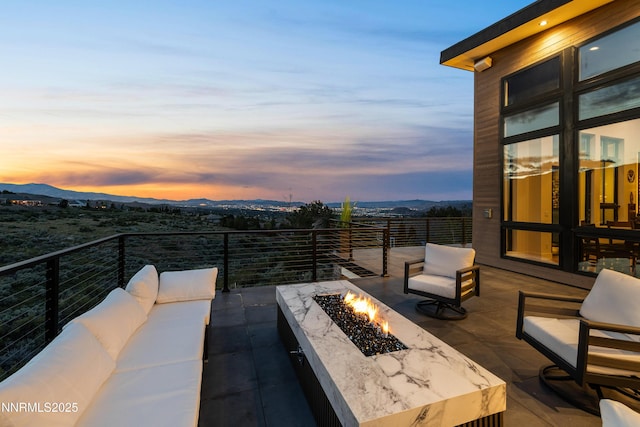 3041 Palmer Pointe Ct, Reno, NV 89511 - patio terrace at dusk with an outdoor living space with a fire pit and a mountain view