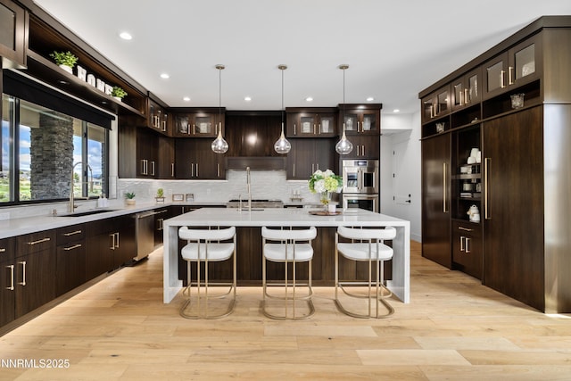 3041 Palmer Pointe Ct, Reno, NV 89511 - kitchen with a sink, stainless steel appliances, an island with sink, dark brown cabinetry, and recessed lighting