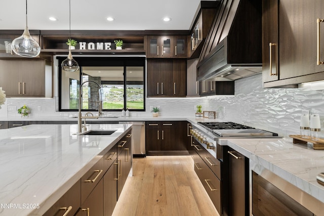 3041 Palmer Pointe Ct, Reno, NV 89511 - kitchen with custom exhaust hood, stainless steel appliances, dark brown cabinetry, light wood-style floors, and a sink