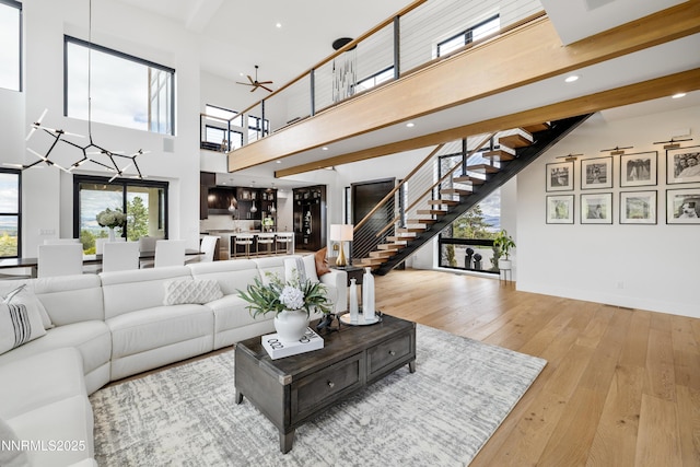 3041 Palmer Pointe Ct, Reno, NV 89511 - living room with stairs, a high ceiling, hardwood / wood-style floors, recessed lighting, and baseboards