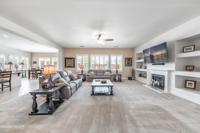 332 Blooming Sage Way, Spanish Springs, NV 89441 - living area featuring ceiling fan, built in shelves, a glass covered fireplace, and light carpet