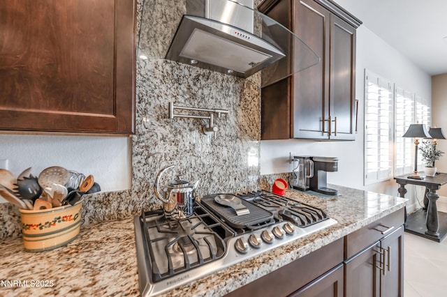 332 Blooming Sage Way, Spanish Springs, NV 89441 - kitchen with wall chimney exhaust hood, stainless steel gas stovetop, dark brown cabinets, and tasteful backsplash