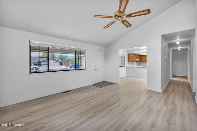 3803 Imperial Way, Carson City, NV 89706 - unfurnished living room featuring a ceiling fan, light wood finished floors, high vaulted ceiling, and baseboards