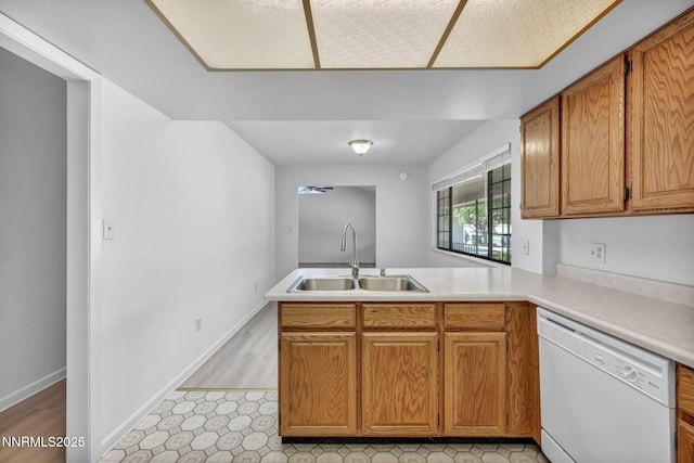 3803 Imperial Way, Carson City, NV 89706 - kitchen featuring white dishwasher, a sink, a peninsula, light countertops, and brown cabinetry