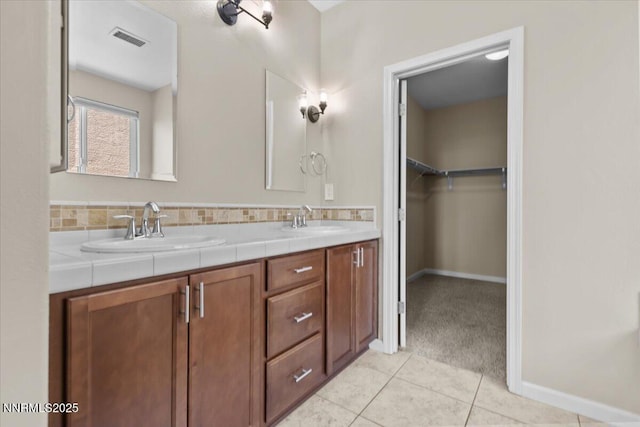 5345 Energystone Dr, Sparks, NV 89436 - bathroom with double vanity, tile patterned floors, a spacious closet, and tasteful backsplash