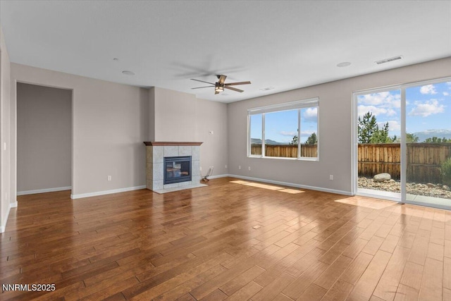 5345 Energystone Dr, Sparks, NV 89436 - unfurnished living room with a ceiling fan, wood finished floors, plenty of natural light, and a tiled fireplace