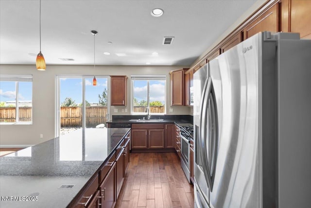 5345 Energystone Dr, Sparks, NV 89436 - kitchen featuring stainless steel appliances, dark stone counters, hanging light fixtures, recessed lighting, and dark wood finished floors