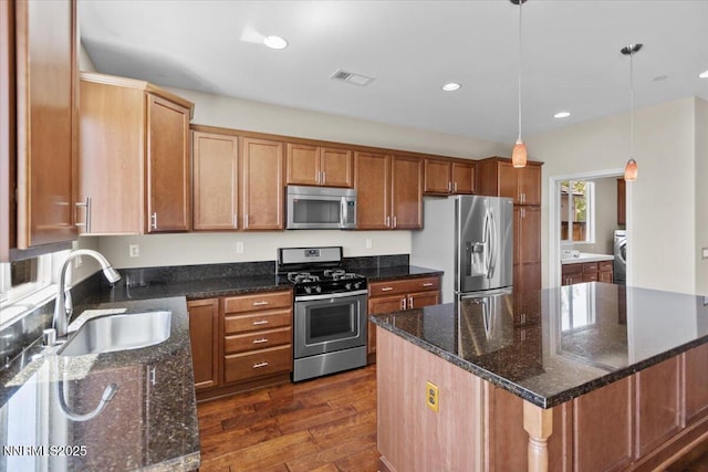 5345 Energystone Dr, Sparks, NV 89436 - kitchen with appliances with stainless steel finishes, washer / dryer, dark wood-type flooring, recessed lighting, and hanging light fixtures