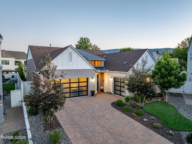 208 Criollo Ct, Reno, NV 89511 - view of front facade featuring an attached garage, a standing seam roof, board and batten siding, decorative driveway, and metal roof