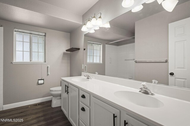 15 Sunlit Ct, Sparks, NV 89441 - bathroom featuring toilet, baseboards, double vanity, a tile shower, and wood finished floors