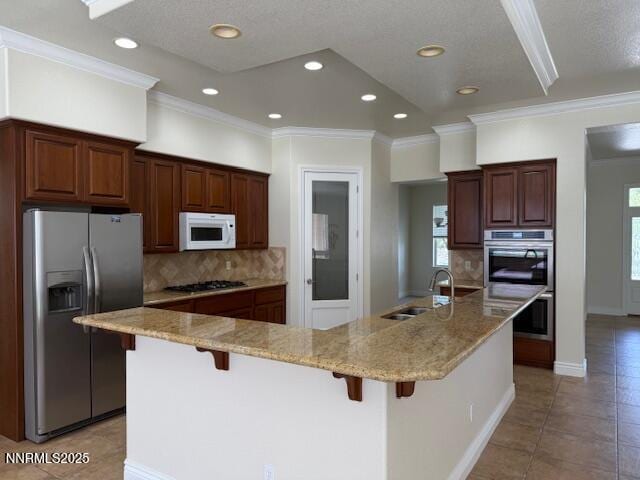 1313 Cedar Creek Cir, Gardnerville, NV 89460 - kitchen featuring stainless steel appliances, recessed lighting, light tile patterned floors, a kitchen bar, and decorative backsplash