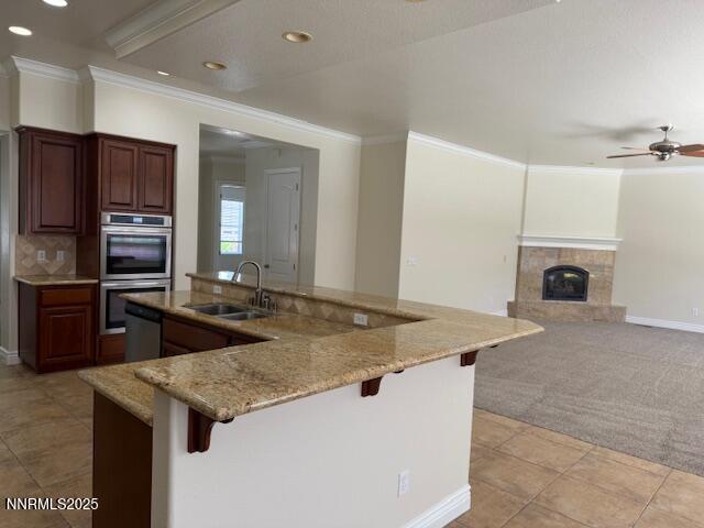 1313 Cedar Creek Cir, Gardnerville, NV 89460 - kitchen featuring stainless steel appliances, light carpet, crown molding, a kitchen bar, and recessed lighting