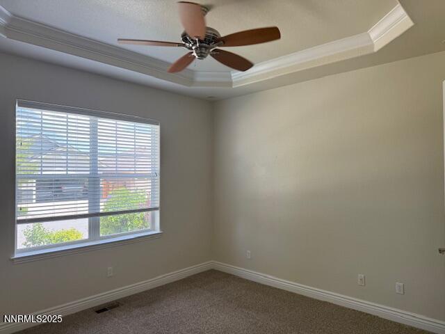 1313 Cedar Creek Cir, Gardnerville, NV 89460 - carpeted empty room featuring a tray ceiling, ornamental molding, and a ceiling fan