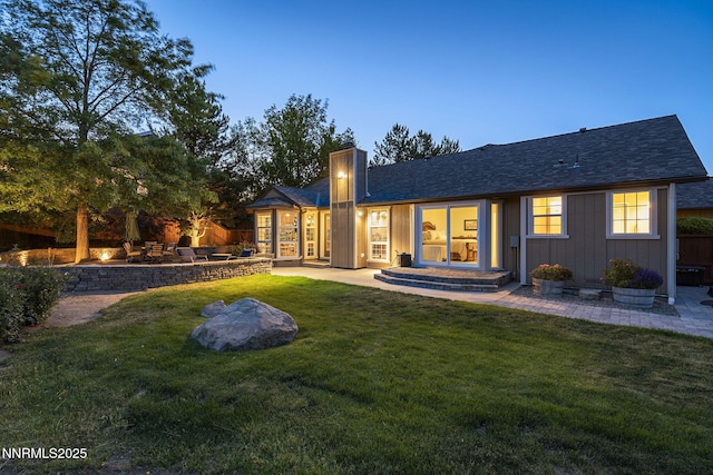 13450 Evening Song Ln, Reno, NV 89511 - back of house with a chimney, a lawn, a patio area, and a shingled roof
