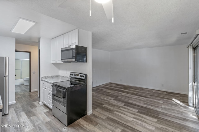 4608 Neil Rd Unit 226, Reno, NV 89502 - kitchen with appliances with stainless steel finishes, wood finished floors, white cabinets, a textured ceiling, and a ceiling fan