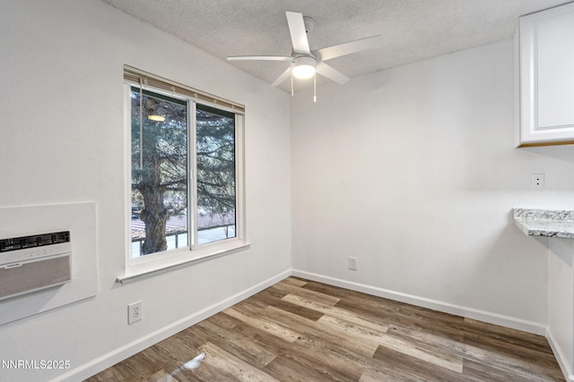 4608 Neil Rd Unit 226, Reno, NV 89502 - unfurnished dining area featuring wood finished floors, a textured ceiling, baseboards, a ceiling fan, and a wall mounted air conditioner