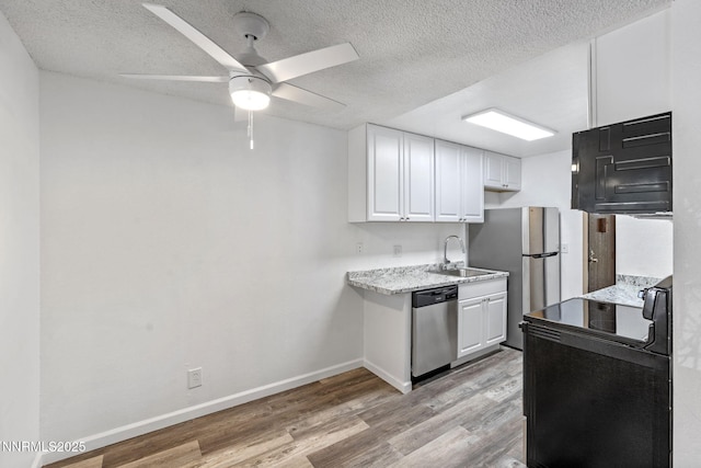 4608 Neil Rd Unit 226, Reno, NV 89502 - kitchen with stainless steel appliances, a sink, light wood-style floors, white cabinets, and a textured ceiling