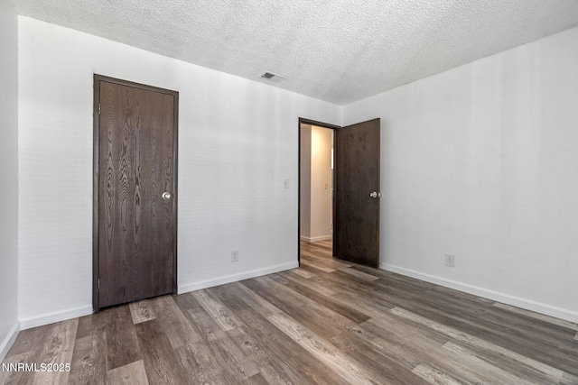 4608 Neil Rd Unit 226, Reno, NV 89502 - unfurnished bedroom featuring wood finished floors, baseboards, a textured ceiling, and a closet
