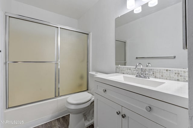 4608 Neil Rd Unit 226, Reno, NV 89502 - bathroom featuring backsplash, vanity, toilet, wood finished floors, and enclosed tub / shower combo