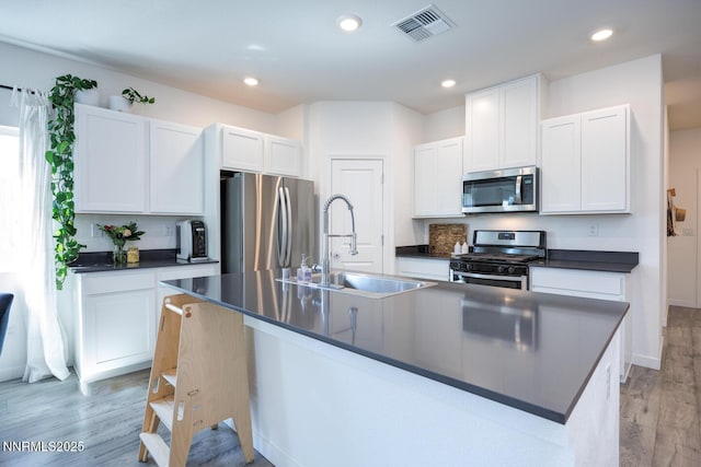 703 Sycamore Dr, Fallon, NV 89406 - kitchen with appliances with stainless steel finishes, dark countertops, a sink, light wood-style floors, and recessed lighting