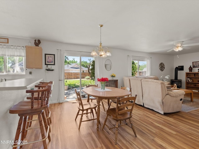 207 Poppy Hills Ct, Fernley, NV 89408 - dining space featuring a wood stove, light wood-type flooring, a ceiling fan, and a chandelier