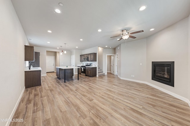 1170 Montevideo Cir, Minden, NV 89423 - living room with recessed lighting, baseboards, light wood-style flooring, a ceiling fan, and a glass covered fireplace