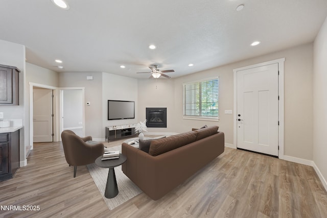 1170 Montevideo Cir, Minden, NV 89423 - living room featuring recessed lighting, ceiling fan, baseboards, light wood finished floors, and a glass covered fireplace