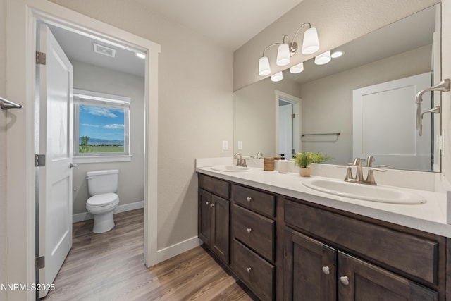 1170 Montevideo Cir, Minden, NV 89423 - full bath with double vanity, toilet, wood finished floors, and baseboards