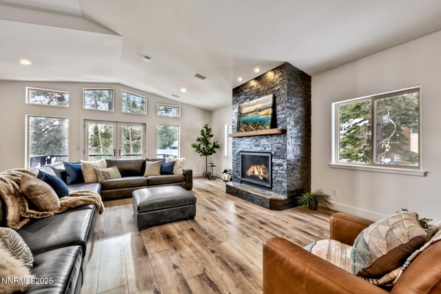 997 Dorcey Dr, Incline Village, NV 89451 - living area with vaulted ceiling, a stone fireplace, light wood finished floors, and baseboards