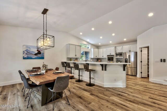 997 Dorcey Dr, Incline Village, NV 89451 - dining area featuring vaulted ceiling, light wood-style floors, recessed lighting, baseboards, and a chandelier