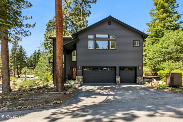 997 Dorcey Dr, Incline Village, NV 89451 - view of front of home with an attached garage, stone siding, and driveway