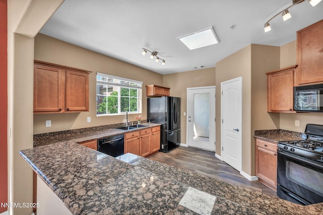 17000 Wedge Pkwy Unit 2624, Reno, NV 89511 - kitchen featuring black appliances, rail lighting, a sink, dark wood-style floors, and dark stone counters