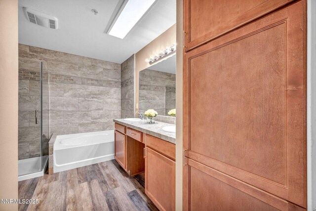17000 Wedge Pkwy Unit 2624, Reno, NV 89511 - bathroom with double vanity, a garden tub, a stall shower, wood finished floors, and tile walls