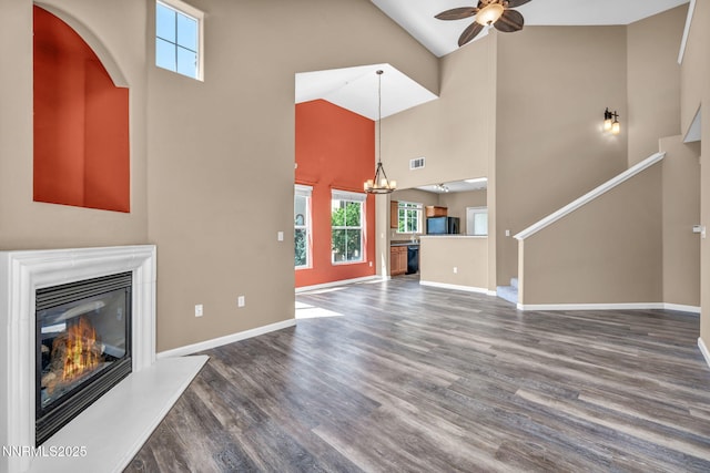 17000 Wedge Pkwy Unit 2624, Reno, NV 89511 - unfurnished living room with high vaulted ceiling, a glass covered fireplace, a ceiling fan, wood finished floors, and a chandelier