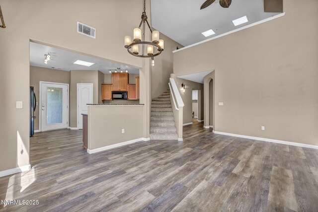 17000 Wedge Pkwy Unit 2624, Reno, NV 89511 - unfurnished living room with high vaulted ceiling, baseboards, stairs, dark wood-type flooring, and a chandelier