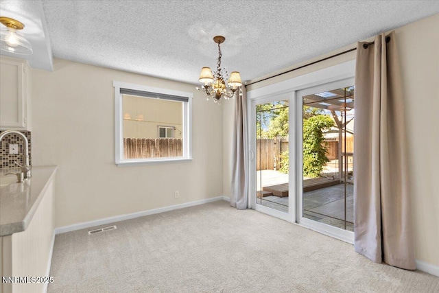 2731 Wabash Cir, Sparks, NV 89434 - unfurnished dining area with a chandelier, carpet floors, baseboards, and a textured ceiling