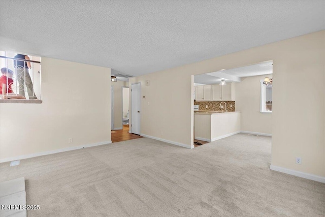 2731 Wabash Cir, Sparks, NV 89434 - unfurnished living room featuring light colored carpet, baseboards, and a textured ceiling
