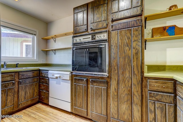 710 Tina Ct # B-2, Stateline, NV 89449 - kitchen featuring oven, dishwasher, open shelves, light wood-style flooring, and light countertops
