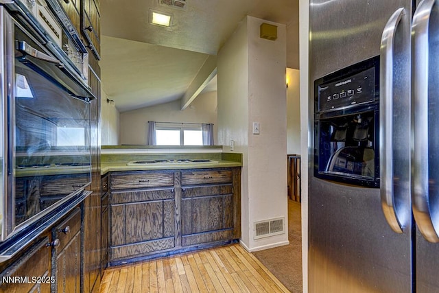 710 Tina Ct # B-2, Stateline, NV 89449 - kitchen with stainless steel fridge with ice dispenser, black oven, stovetop, vaulted ceiling, and dark brown cabinets