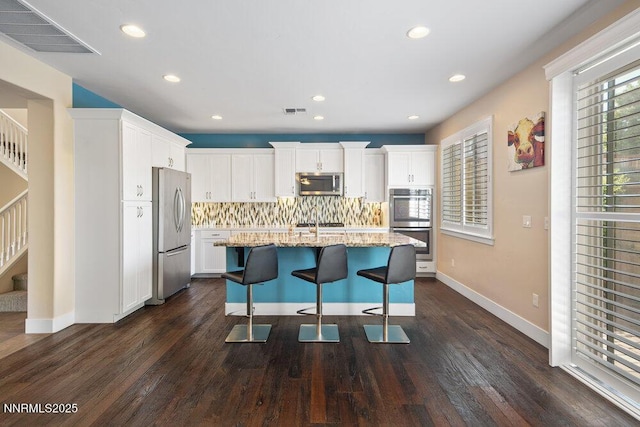 1385 Balfour Dr, Reno, NV 89509 - kitchen with stainless steel appliances, backsplash, light stone countertops, dark wood-style flooring, and white cabinets