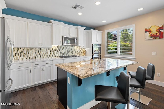 1385 Balfour Dr, Reno, NV 89509 - kitchen with stainless steel appliances, tasteful backsplash, white cabinetry, dark wood-type flooring, and recessed lighting