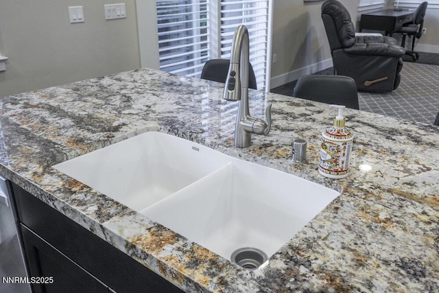 1385 Balfour Dr, Reno, NV 89509 - kitchen view of a sink, stone counters, and dark cabinets