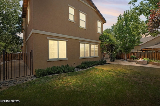 7121 Jermann Dr, Sparks, NV 89436 - view of side of home with stucco siding, a fenced backyard, and a patio area