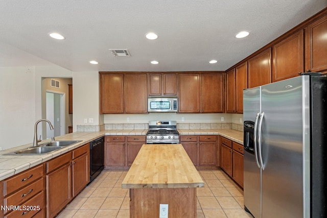 7121 Jermann Dr, Sparks, NV 89436 - kitchen featuring appliances with stainless steel finishes, butcher block countertops, a peninsula, a kitchen island, and light tile patterned floors