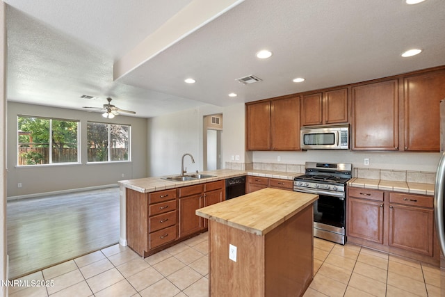 7121 Jermann Dr, Sparks, NV 89436 - kitchen with appliances with stainless steel finishes, a peninsula, butcher block countertops, a ceiling fan, and recessed lighting